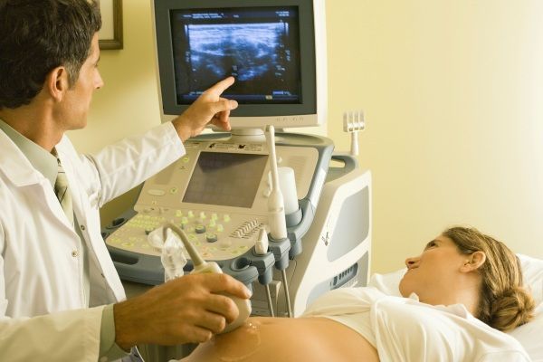 Donna incinta utilizzando uno stetoscopio per ascoltare il suo