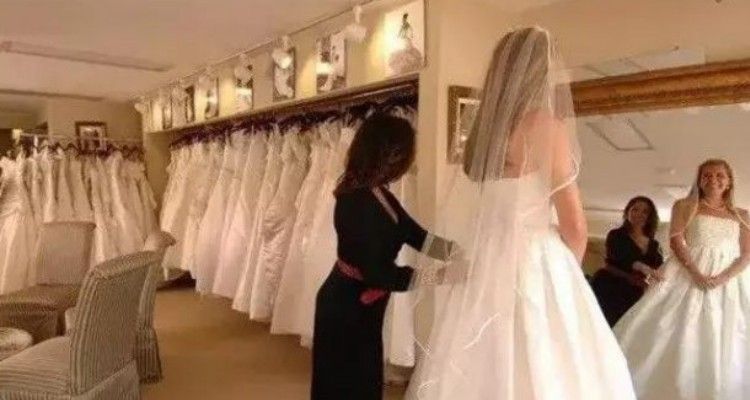 Mamma e figlia si divertono a deridere una futura sposa in carne mentre prova il vestito