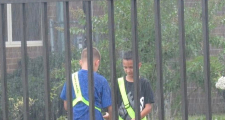 Insegnate scopre due studenti nel cortile della scuola, sotto la pioggia